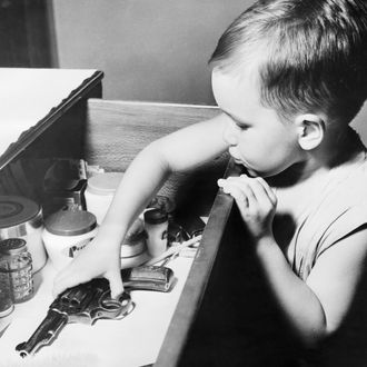 Boy picking up a revolver from a drawer