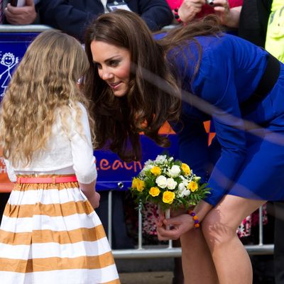 Kate accepts flowers from a child at the Treehouse Hospice in Ipswich, England.