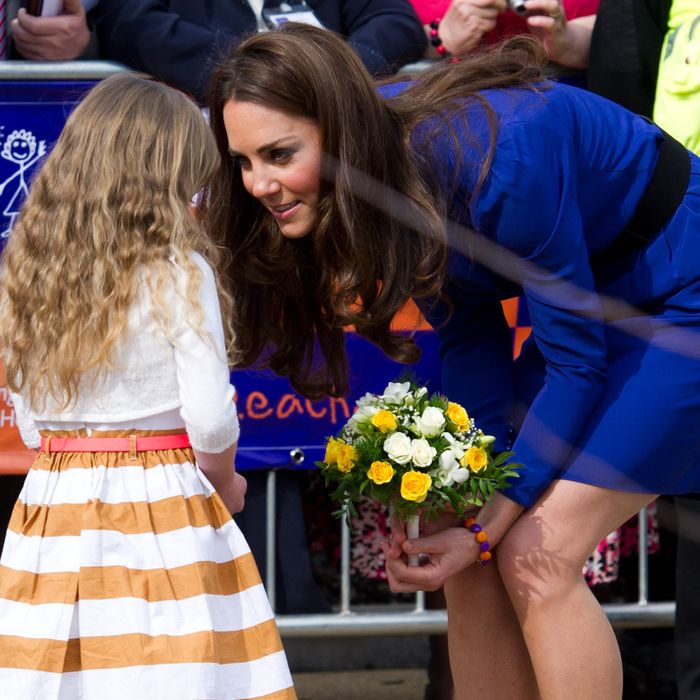 Kate accepts flowers from a child at the Treehouse Hospice in Ipswich, England.