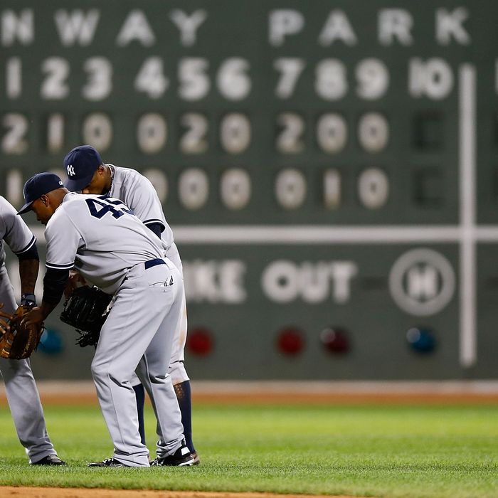 Andruw Jones #22, Curtis Granderson #14, and Dewayne Wise #45 of the New York Yankees celebrate in center field after their win against the Boston Red Sox during the game on July 8, 2012 at Fenway Park in Boston, Massachusetts.