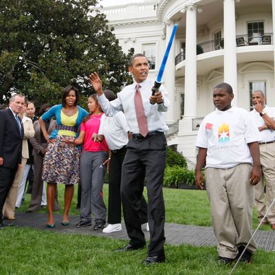 President Barack Obama uses a light saber as he watches a demonstration of fencing at an event supporting Chicago's 2016 host city Olympic bid, Wednesday, Sept. 16, 2009, on the South Lawn of the White House in Washington. At rear is Chicago Mayor Richard Daley and first lady Michelle Obama. 