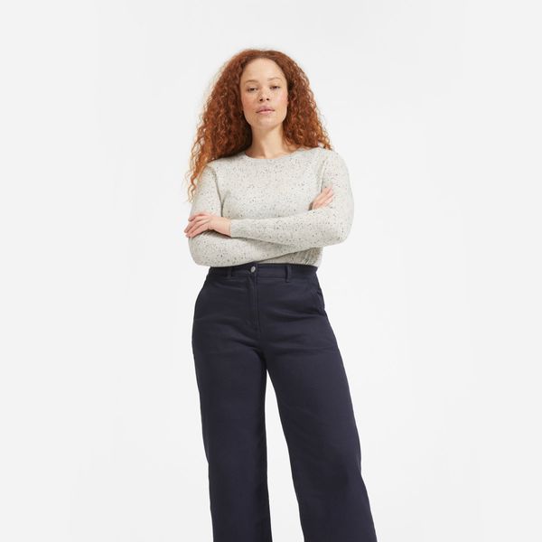 Everlane Cashmere Crew, Frost Donegal soft cream cashmere sweater with a subtle black pattern and high waisted black jeans on a model with red curly hair. The Strategist - 33 Things on Sale You’ll Actually Want to Buy: From Adidas to Le Creuset