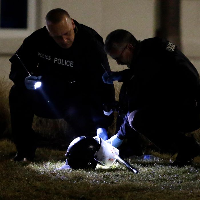 Police shine a light on a helmet as they investigate the scene where two police officers were shot outside the Ferguson Police Department Thursday, March 12, 2015, in Ferguson, Mo. (AP Photo/Jeff Roberson)