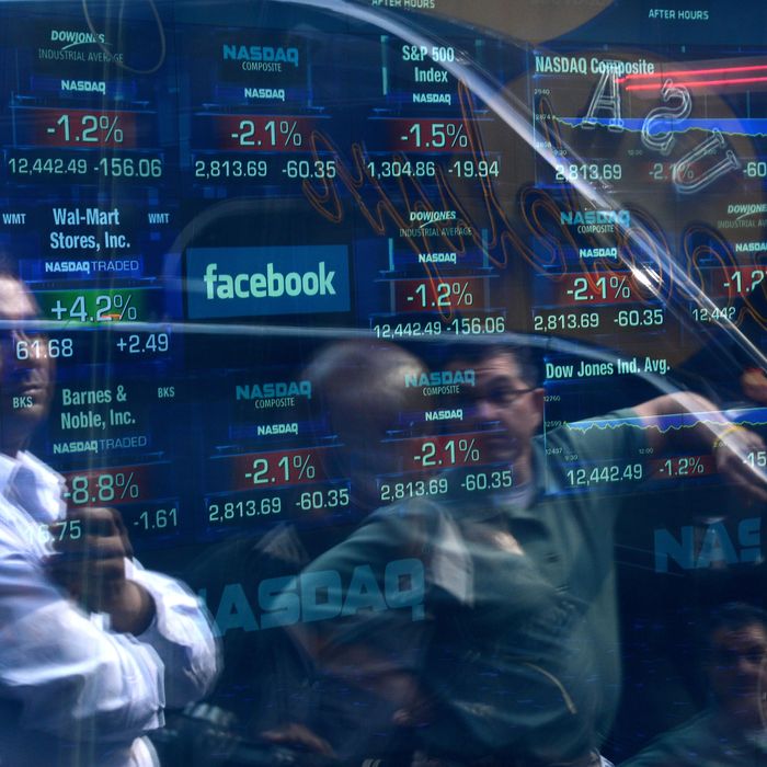 A Facebook logo is seen through the windows of the NASDAQ stock exchange as people walk by on Times Square in New York, May 17, 2012. Facebook is set to go public on May 18, 2012 and is likely to have an estimated market valuation of over 100 billion USD when its shares begin trading on the NASDAQ. 