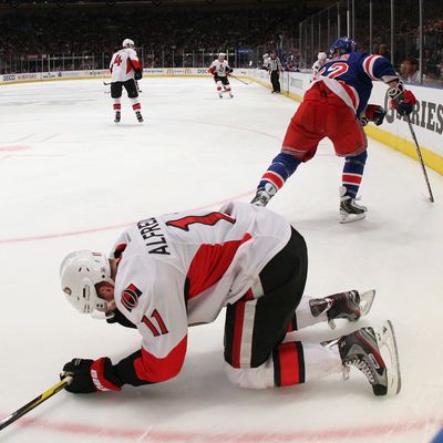 Daniel Alfredsson #11 of the Ottawa Senators lays on the ice following an elbow from Carl Hagelin #62 of the New York Rangers