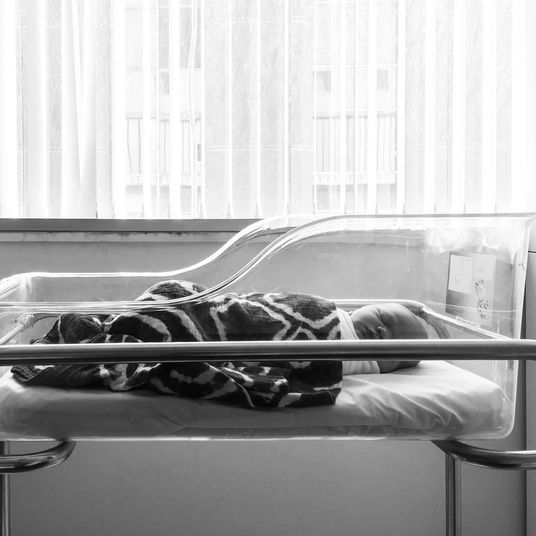 Newborn baby sleeping in hospital bassinet