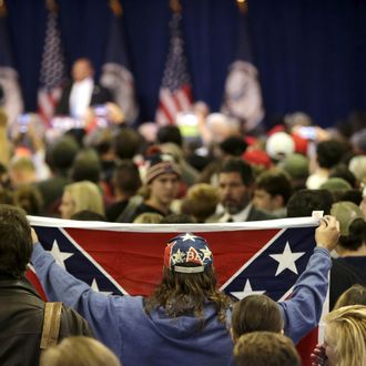 Supporter of Republican presidential candidate Trump holds up Confederate flag at a campaign rally in Manassas, Virginia