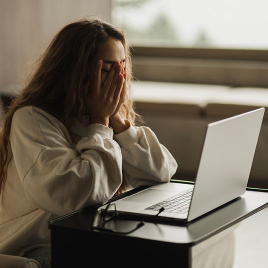 Tired woman in depression after problems with online business. Working on laptop.
