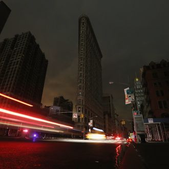 NEW YORK, NY - OCTOBER 30: Cars are blurred as they pass by a darkened Flatiron Building in a section of Manhattan still in a blackout following Hurricane Sandy on October 30, 2012 in New York City. The storm has claimed at least 40 lives in the United States, and has caused massive flooding across much of the Atlantic seaboard. US President Barack Obama has declared the situation a 'major disaster' for large areas of the US East Coast including New York City. (Photo by Mario Tama/Getty Images)