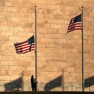 A National Park Service employee lowers flags at the base of the Washington Monument to half staff after President Barack Obama ordered the action while speaking on the shootings at the Sandy Hook Elementary School December 14, 2012 in Washington, DC. Obama called for 