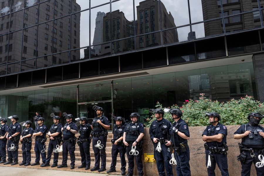A line of NYPD officers stand in front of 26 Federal Plaza in downtown Manhattan. 