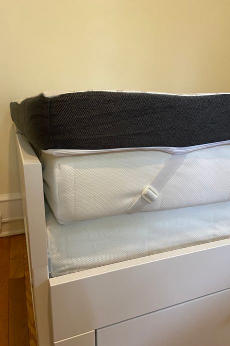 The corner of a mattress topper with an elastic strap.