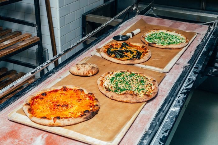 四块新鲜比萨 冷却带巨型烤箱