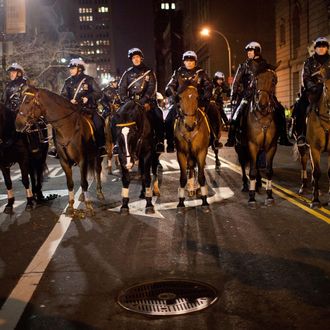 NEW YORK, NY - NOVEMBER 17: Police on horseback monitor protestors affiliated with the Occupy Wall Street movement during a march past City Hall on November 17, 2011 in New York City. The day has been marked by sporadic violence, arrests, and injuries sustained by both protestors and police. Protestors marched around Wall Street throughout the morning, attempting to disrupt businesses from operating. (Photo by Andrew Burton/Getty Images)
