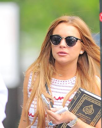 Lindsay Lohan carrying a book (the Koran).