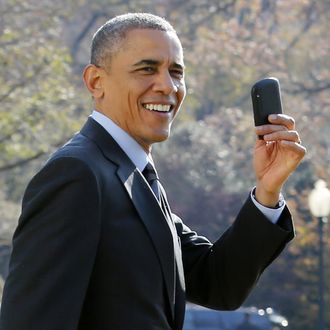 US President Barack Obama shows his Blackberry as he walks on the South Lawn of the White House in Washington, DC. Obama forgot to take his Blackberry devise and returned to pick it up at The White House before his departure to Las Vegas, Nevada on November 21, 2014. 