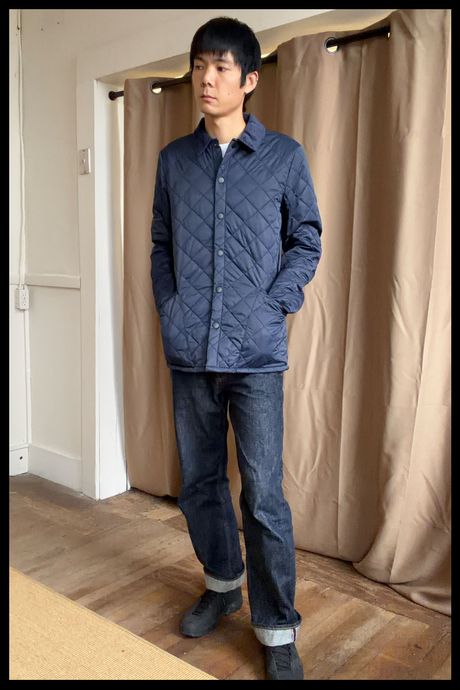 Photo of Strategist senior writer Michael Zhao wearing the Quince Men's Featherless Quilted Jacket in blue. 