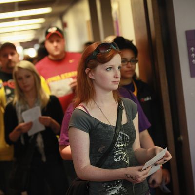 CEDAR FALLS, IA - SEPTEMBER 28: Students wait in line to vote on the campus of the University of Northern Iowa (UNI) on September 28, 2012 in Cedar Falls, Iowa. Most of the voters in the line walked from a nearby rally with first lady Michelle Obama to the polling place to cast their votes. Yesterday Iowa began early voting in select locations throughout the state. (Photo by Scott Olson/Getty Images)