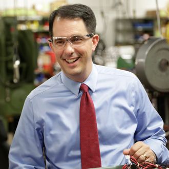 In this Sept. 23, 2014 photo Wisconsin Repubican Gov. Scott Walker makes a re-election campaign stop at a small business in Racine, Wis. 