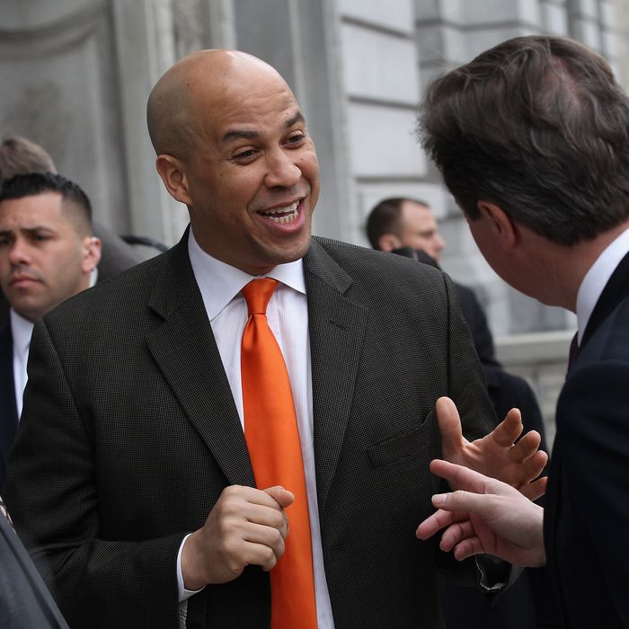 British Prime Minister David Cameron (R), speaks with Essex County Executive Joe DiVincenzo (L), and Newark Mayor Cory Booker on March 15, 2012 at City Hall in Newark, New Jersey. Cameron visited Newark on the third and final day of his visit to the United States.