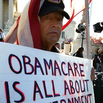 WASHINGTON, DC - MARCH 26: Ron Kirby holds a sign while marching in protest of the Patient Protection and Affordable Care Act in front of the U.S. Supreme Court on March 26, 2012 in Washington, DC. Today the high court, which has set aside six hours over three days, will hear arguments over the constitutionality President Barack Obama's Patient Protection and Affordable Care Act. (Photo by Mark Wilson/Getty Images)