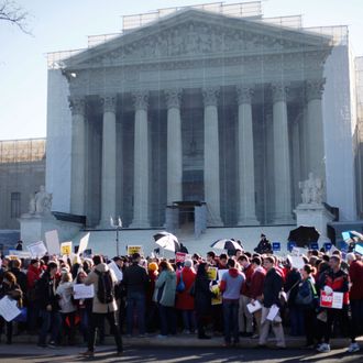 Demonstrators stand outside the Supreme Court in Washington, Tuesday, March 26, 2013, where the court will hear arguments on California’s voter approved ban on same-sex marriage, Proposition 8.