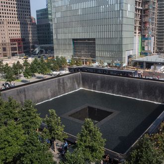 People gather around the NorthTower pool during memorial ceremonies for the twelfth anniversary of the terrorist attacks on lower Manhattan at the World Trade Center site on September 11, 2013 in New York City. 