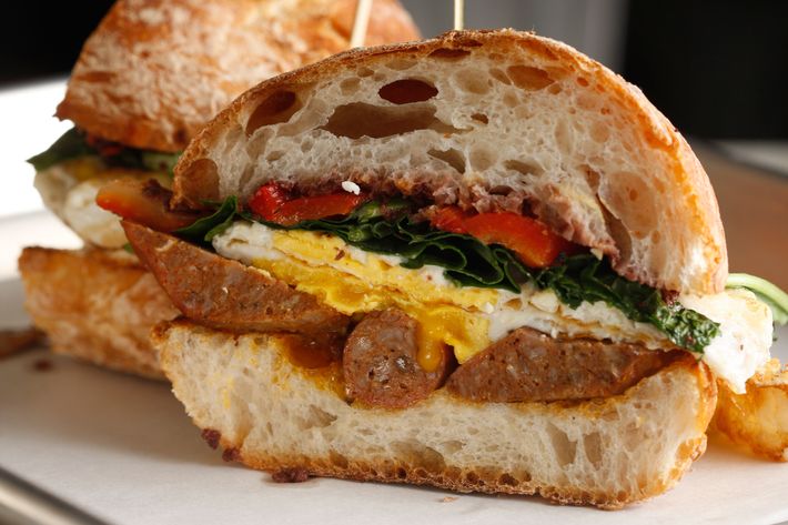 Greeky-Roman: lamb sausage, feta, roasted peppers, baby kale, olive tapenade, Pugliese roll.