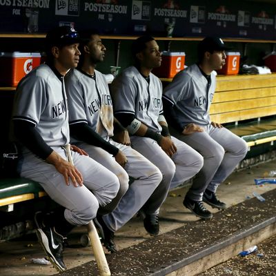 (L-R) Alex Rodriguez #13, Eduardo Nunez #26, Robinson Cano #24 and Mark Teixeira #25 of the New York Yankees look on from the dugout late in the game against the Detroit Tigers during game four of the American League Championship Series at Comerica Park on October 18, 2012 in Detroit, Michigan.