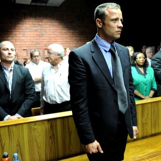 South African Olympic sprinter Oscar Pistorius (C) appears on February 19, 2013 at the Magistrate Court in Pretoria as he father Henke (3rd L), brother Carl (2nd L) and sister Aimee (L) attend. Pistorius battled to secure bail as he appeared on charges of murdering his model girlfriend Reeva Steenkamp on February 14, Valentine's Day. South African prosecutors will argue that Pistorius is guilty of premeditated murder in Steenkamp's death, a charge which could carry a life sentence.