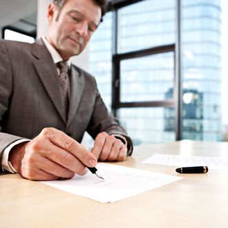 Businessman signing document at desk