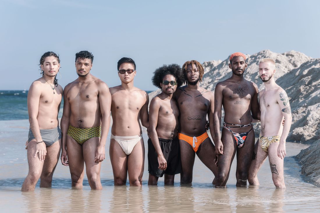 Topless ladies surrounded by dressed men at the beach