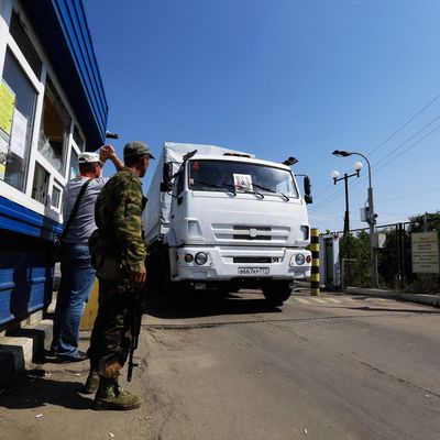 Ukrainian border guards look at the first aid truck as it passes the border post at Izvaryne, eastern Ukraine, Friday, Aug. 22, 2014. The first trucks in a Russian aid convoy crossed into eastern Ukraine on Friday, seemingly without Kiev's approval, after more than a week's delay amid suspicions the mission was being used as a cover for an invasion by Moscow. (AP Photo/Sergei Grits)