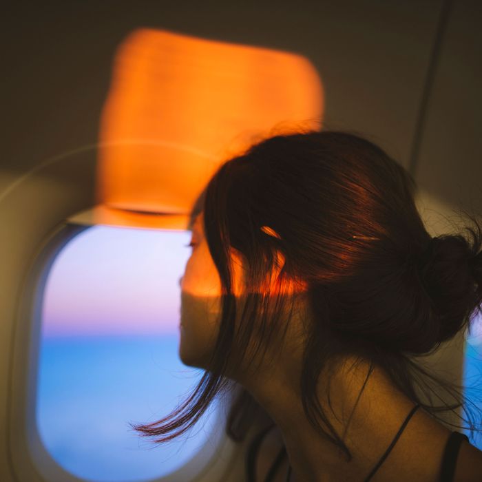 Portrait of young woman in plane illuminated with sunset light