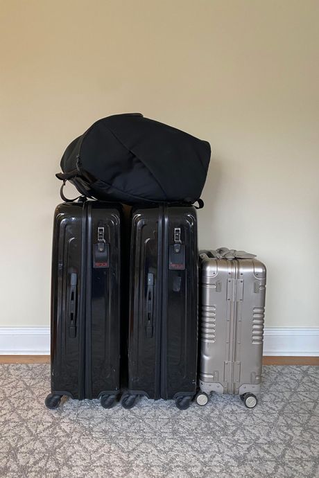 Una mochila que contiene la silla de viaje para coche Wayb, junto con tres maletas. 