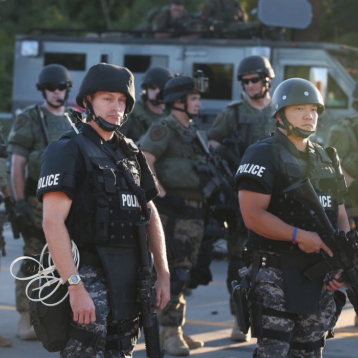 FERGUSON, MO - AUGUST 12: Police take up position to control demonstrators who were protesting the killing of teenager Michael Brown on August 12, 2014 in Ferguson, Missouri. Brown was shot and killed by a police officer on Saturday in the St. Louis suburb of Ferguson. Ferguson has experienced two days of violent protests since the killing but, tonight's protest was peaceful. (Photo by Scott Olson/Getty Images)