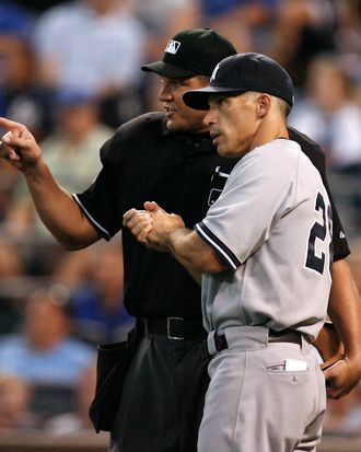 Manager Joe Girardi of the New York Yankees talks with plate umpire Chad Fairchild after Billy Butler's of the Kansas City Royals home run was reviewed in the third inning on August 17, 2011 in Kansas City, Missouri.