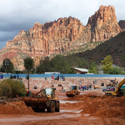 Onlookers watch as construction equipment removes flood debris from Short Creek as it crosses Central Street on September 15, 2015 in Colorado City, Arizona. 