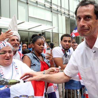 Anthony Weiner, running in the New York Mayors race, right, reacts after sharing a moment with a spectator and her plantains, left, as he takes part in the Dominican Day Parade on New York's Avenue of the Americas Sunday Aug. 11, 2013. (AP Photo/Tina Fineberg)
