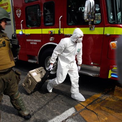 A police forensic expert arrives at a blast site at a subway station in Santiago, Chile, Monday Sept. 8, 2014. A bomb exploded in the Chilean subway station injuring at least seven people, the most damaging in a string of bombs planted around the country's capital this year. (AP Photo/ Luis Hidalgo)