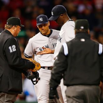 Home plate umpire Gerry Davis checks out the hand of Michael Pineda #35 of the New York Yankees in front of teammate Derek Jeter #2 before throwing him out of the game in the second inning against the Boston Red Sox during the game at Fenway Park on April 23, 2014 in Boston, Massachusetts. 