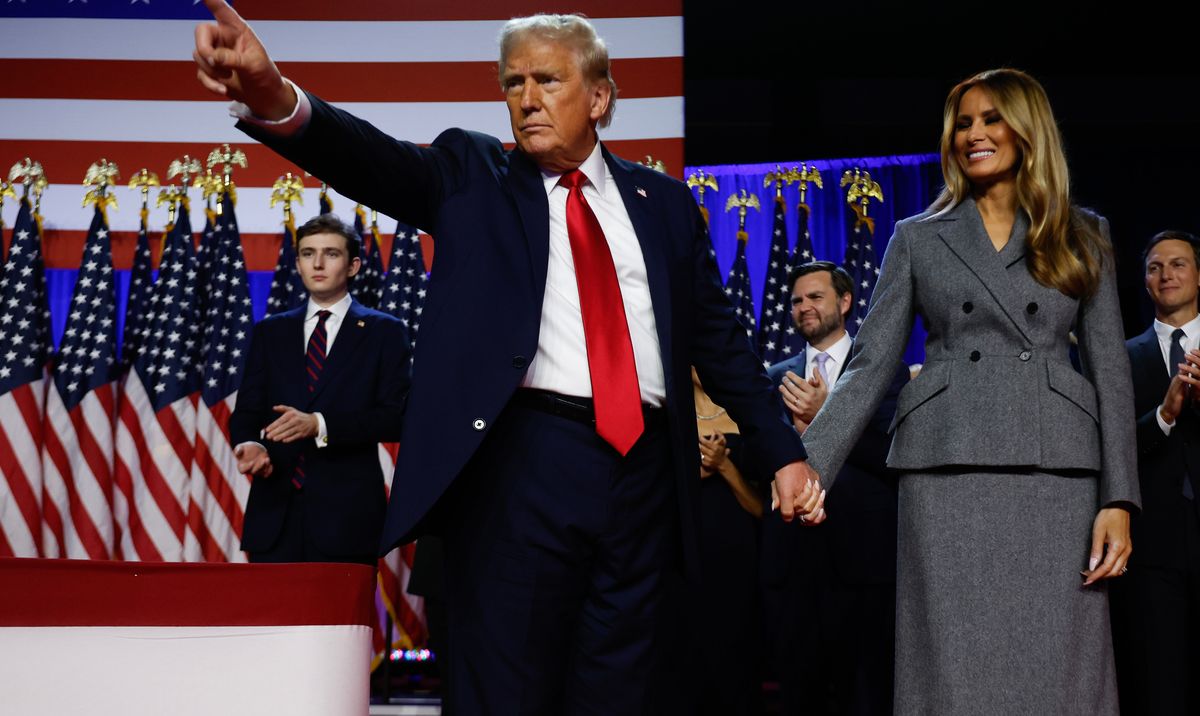 Donald Trump points to supporters with former first lady Melania Trump during an election night event