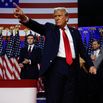 Donald Trump points to supporters with former first lady Melania Trump during an election night event