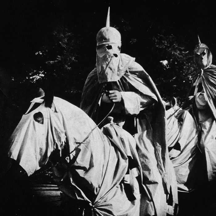 Actors costumed in the full regalia of the Ku Klux Klan ride on horses at night in a still from 'The Birth of a Nation,' the first-ever feature-length film, directed by D. W. Griffith, 1914. 