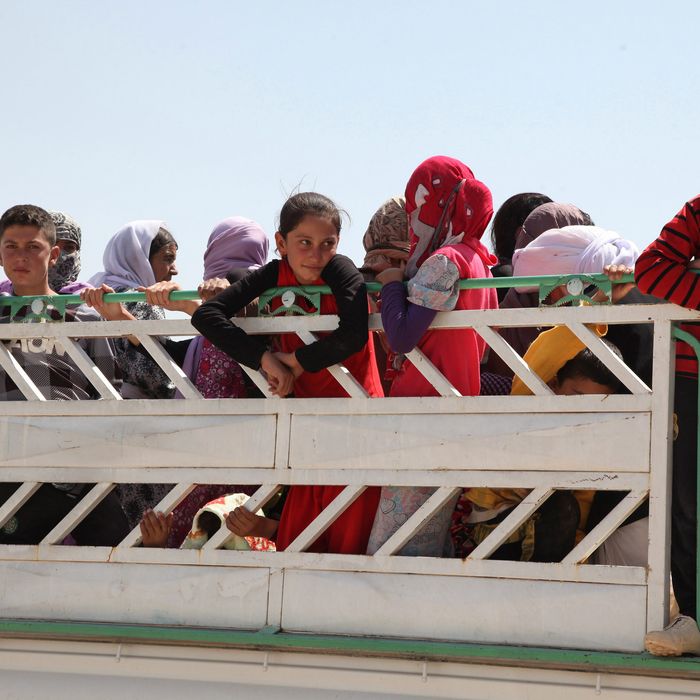 04 Aug 2014, Dohuk, Iraq --- Displaced families from the minority Yazidi sect, fleeing the violence in the Iraqi town of Sinjarl west of Mosul, arrive at Dohuk province, August 4, 2014. Iraq's Prime Minister Nuri al-Maliki ordered his air force for the first time to back Kurdish forces against Islamic State fighters after the Sunni militants made another dramatic push through the north, state television reported on Monday. REUTERS/Ari Jala (IRAQ - Tags: CIVIL UNREST POLITICS) --- Image by ? STRINGER/IRAQ/Reuters/Corbis
