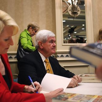 Republican presidential hopeful and former Speaker of the House Newt Gingrich and his wife Callista sign books after speaking at a Hilton Hotel on November 25, 2011 in Naples, Florida. 