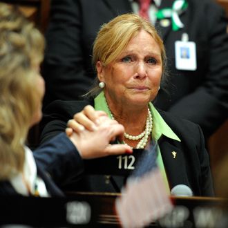 State Rep. DebraLee Hovey, R-112 district, including Newtown, grabs the hand of colleague Rep. Laura Hoydick, R-Stratford, left, after speaking at a memorial service for the victims of the Sandy Hook Elementary School shooting before the House of Representatives and Senate meet for special session the state Capitol in Hartford, Conn., Wednesday, Dec. 19, 2012.