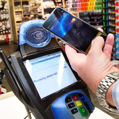IMAGE DISTRIBUTED FOR MASTERCARD - A customer makes a purchase with a MasterCard using Apple Pay on the iPhone 6 at Walgreens in Times Square, Monday, Oct. 20, 2014, in New York. The service launched Monday. (John Minchillo/AP Images for MasterCard)