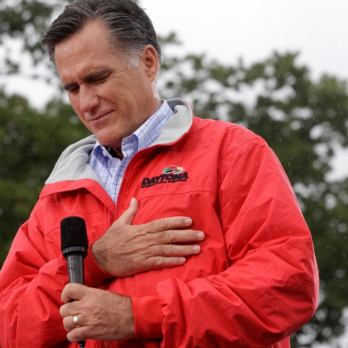 Republican presidential candidate, former Massachusetts Gov. Mitt Romney puts his hand on his heart during a moment of silence for the embassy officials killed in Libya, as he campaigns in the rain at Lake Erie College in Painesville, Ohio, Friday, Sept. 14, 2012. (AP Photo/Charles Dharapak)