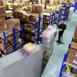 Workers walk between shelves at a distribution center in Hefei City, capital of east China's Anhui Province, Nov. 11, 2015. E-commerce transactors got busy on the annual Singles Day which fell on Wednesday.